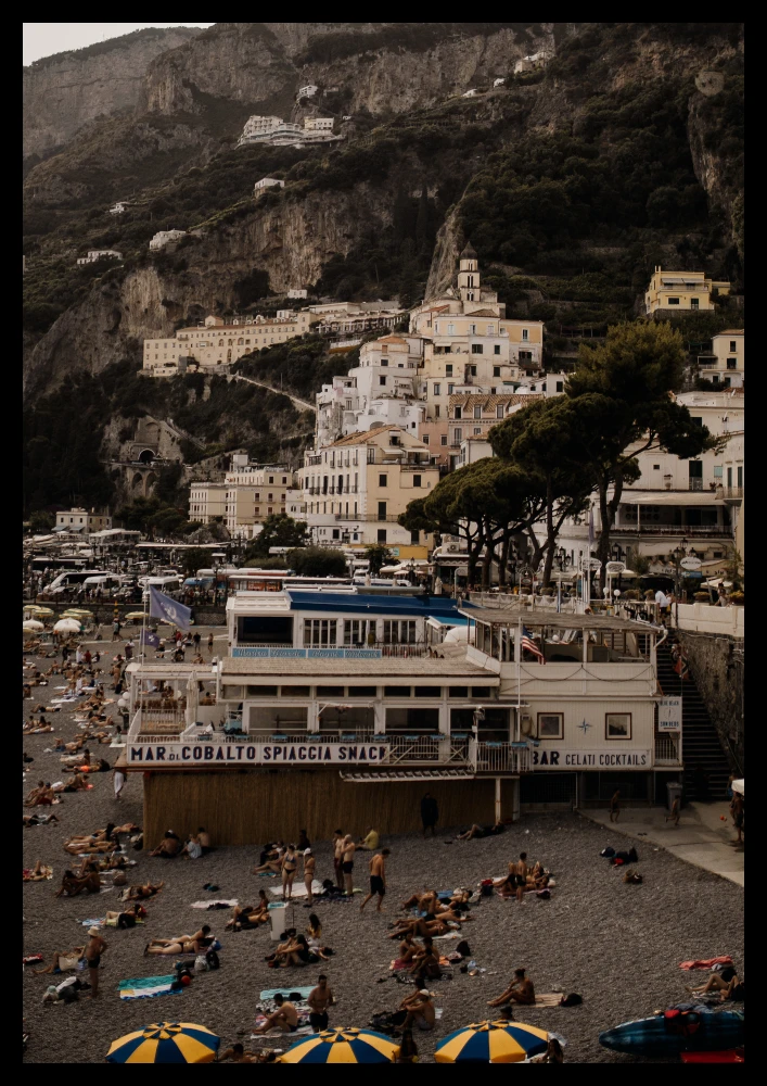 Retro plakat niebiesko żółte parasole na plaży i widok na włoskie zabudowania w Amalfi
