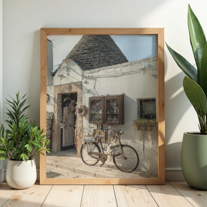 Dekoracyjny plakat z widokiem na mały włoski sklepik w Alberobello i stojący przy nim rower